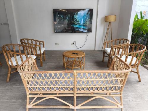 a room with chairs and a table and a tv at Omah Gili Hotel in Gili Air