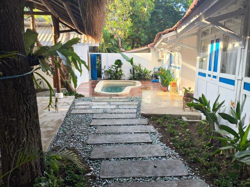 a garden with a stone walkway and a swimming pool at Omah Gili Hotel in Gili Air