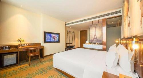 a bedroom with a large white bed and a desk at James Joyce Coffetel Chengdou Wuqing Wanda Plaza in Chengdu