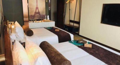a hotel room with two beds and a television at James Joyce Coffetel Chengdou Wuqing Wanda Plaza in Chengdu