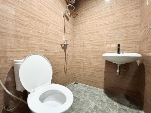 a bathroom with a toilet and a sink at Tini's Guest House Malang Mitra RedDoorz in Betek