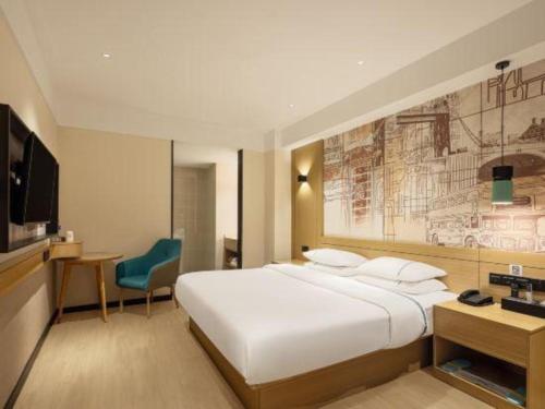 a bedroom with a large white bed and a television at City Comfort Inn Ji'an South Administrative Center in Ji'an