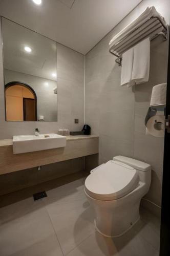 a white bathroom with a toilet and a sink at HOTEL D EDITION in Daejeon