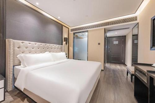 a large white bed in a hotel room at Xana Hotelle Zhuhai Gongbei Port in Zhuhai
