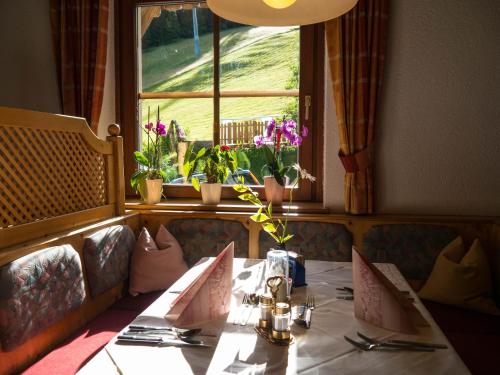 a dining room with a table and a window at Familienhotel Gasthof Hinteregger in Bad Kleinkirchheim