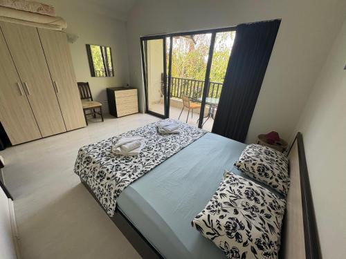 a bedroom with a bed and a balcony at The White Houses Complex in Nesebar