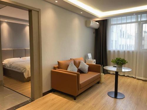 una camera con divano, letto e specchio di GreenTree Inn Hefei East Wangjiang Road CTCE Express Hotel a Hefei