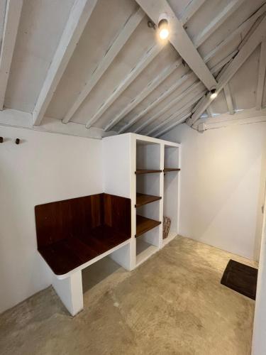 a room with a shelf and a tv on the wall at Omah Gili Hotel in Gili Air
