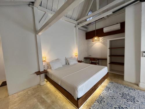 a bedroom with a large white bed in a room at Omah Gili Hotel in Gili Air
