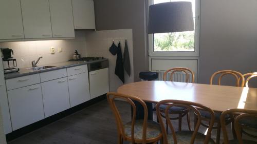 cocina con mesa de madera, mesa y sillas en Solo Bungalow, en Makkum