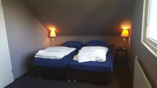 マックムにあるSolo Bungalowの小さな部屋 ベッド2台 ランプ2つ付