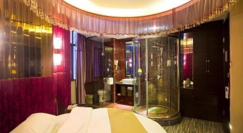 a bathroom with a shower and a bed in a room at GreenTree Inn Jiangxi Yingtan Jiaotong Road Central Square Business Hotel in Yingtan