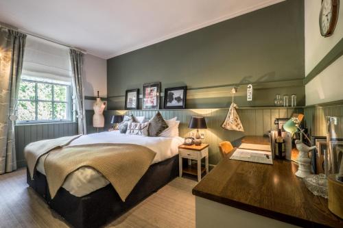 a bedroom with a large bed and a desk at The Windmill On The Common in London
