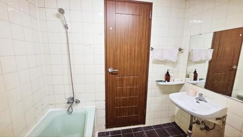 a bathroom with a bath tub and a sink at 삼우텔 in Changwon