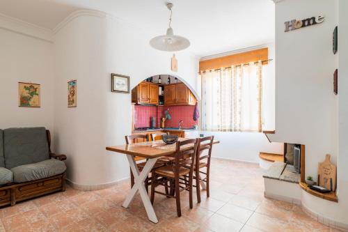 a kitchen and dining room with a table and chairs at Sa omu de sa palgia in Jerzu