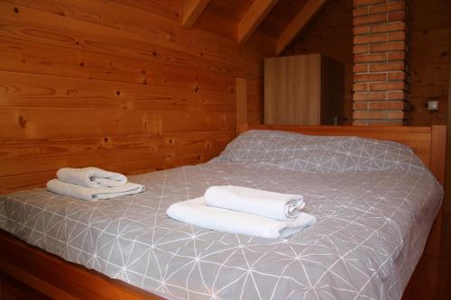 two towels on a bed in a wooden cabin at LAna in Šipovo