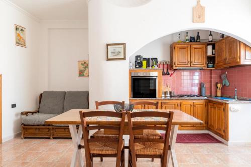 a kitchen and dining room with a table and chairs at Sa omu de sa palgia in Jerzu
