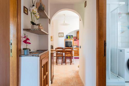 a kitchen with an archway leading into a dining room at Sa omu de sa palgia in Jerzu