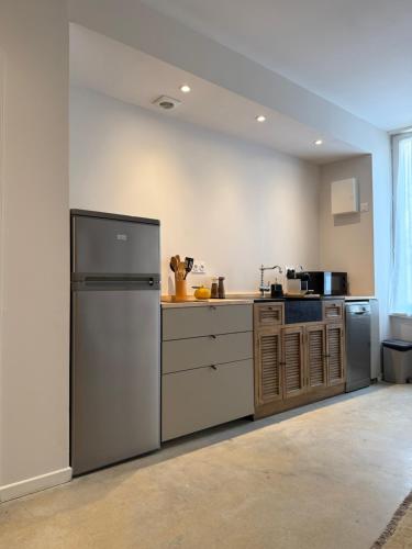 a kitchen with a stainless steel refrigerator and cabinets at Studio du Cherche Midi in Jarnac