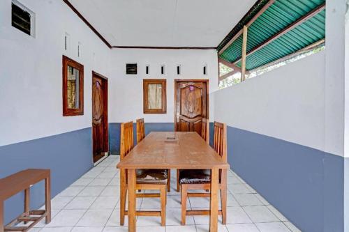 a dining room with a wooden table and chairs at OYO 90405 Penginapan Sasti Kuningan in Kuningan