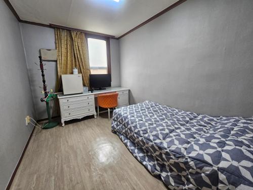a bedroom with a bed and a desk and a window at 삼우텔 in Changwon