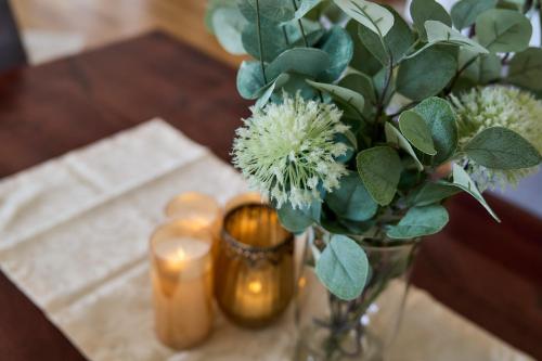 a vase with flowers and candles on a table at Bergkranz Apartments in Seefeld in Tirol