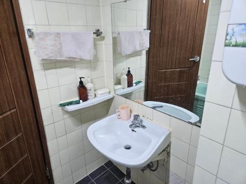 a white bathroom with a sink and a mirror at 삼우텔 in Changwon