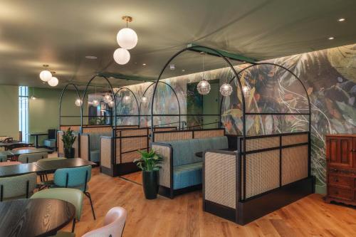 a restaurant with tables and chairs in a room at Hotel Indigo London Clerkenwell by IHG in London