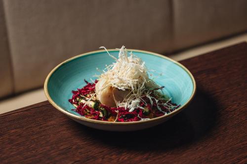 a blue bowl of food on a wooden table at Hotel Indigo London Clerkenwell by IHG in London