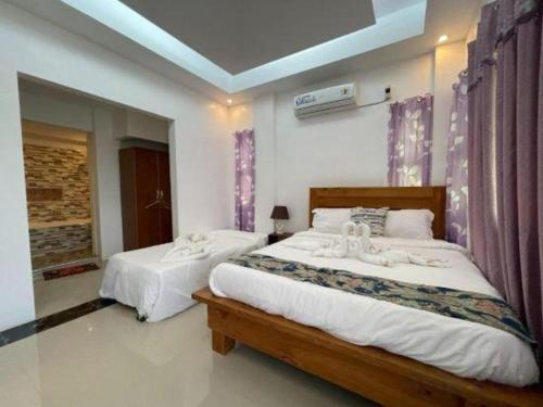 a bedroom with two beds with white sheets at Pilot Hotel in Alaminos