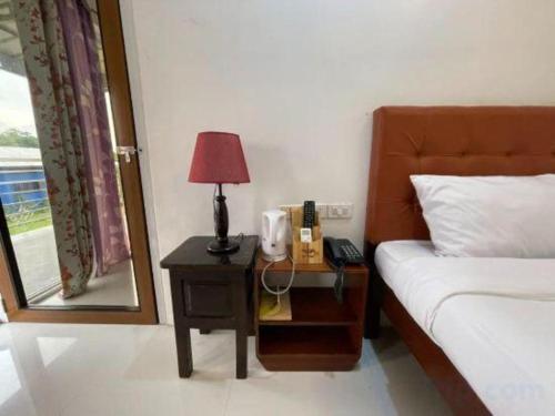 a bedroom with a bed and a table with a lamp at Pilot Hotel in Alaminos