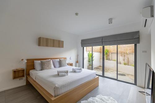 Un dormitorio con una cama grande y una ventana grande. en Studio 365 Serviced Apartments, en Chiang Mai