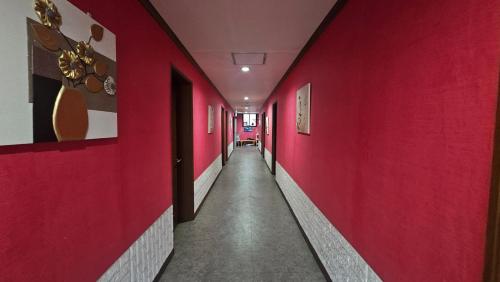 a corridor with red walls and a long hallway at 삼우텔 in Changwon