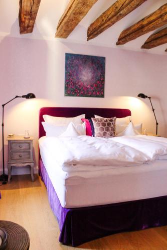 a bedroom with a large white bed with two lamps at Gästehaus im Weingut am Nil in Kallstadt