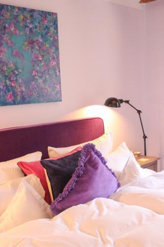a bedroom with a bed with pillows and a lamp at Gästehaus im Weingut am Nil in Kallstadt