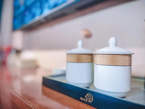 two cups sitting on top of a table at Ronghe River View Homestay in Fenghuang