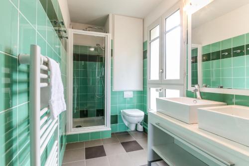 a green bathroom with a sink and a toilet at Maya - Piscine - Calme - Parking in Baden