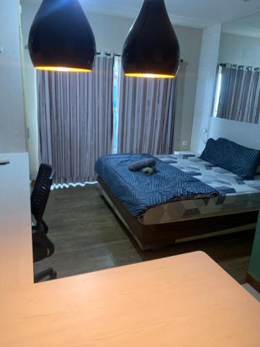 a bedroom with a bed and two lights above it at Student park Apartment by ATA in Seturan