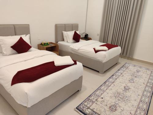 a bedroom with two beds and a rug at MY HOTEL Oasis Majan Pool Chalets and Rooms in Ma‘mad