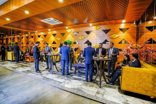 a group of people standing at tables in a restaurant at FabHotel La Victoria - Galaxy Circle in Surat