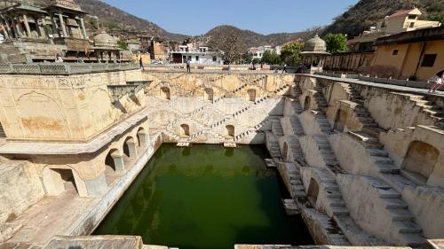 a bridge over a river with green water at House of Amer in Jaipur