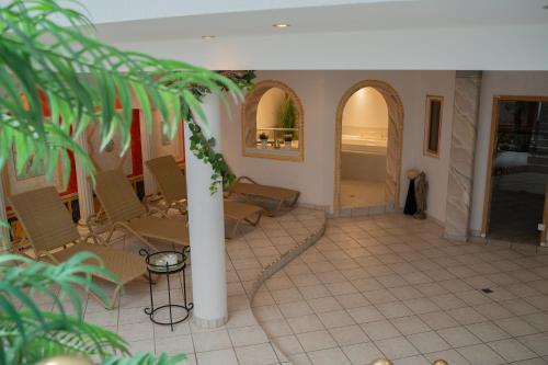 a room with chairs and a table and a column at Alpenhotel Regina in Nauders