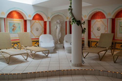 a room with chairs and a statue in it at Alpenhotel Regina in Nauders