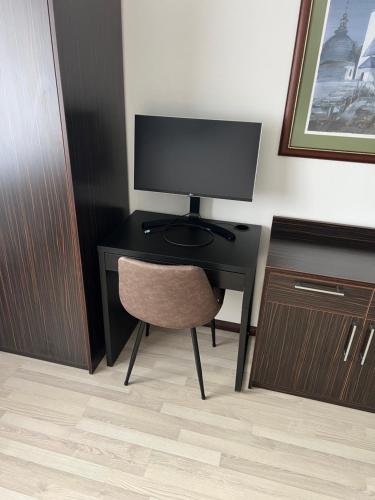 a desk with a monitor and a chair in a room at Havasi View Donovaly - 2 Bedrooms, Mountain View, Garage, 2 WC, Balcony, Dishwasher, Guitar, 164 cm TV, Netflix in Donovaly