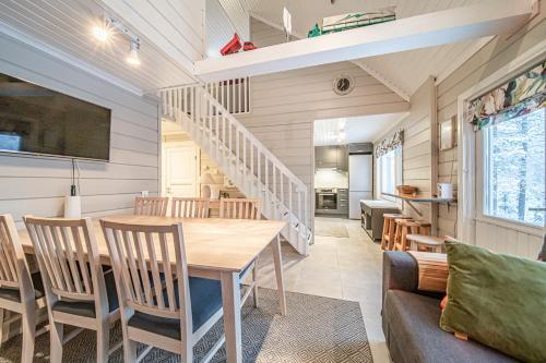 a dining room and living room with a table and chairs at Lavi Chalet by Aavalevi in Levi