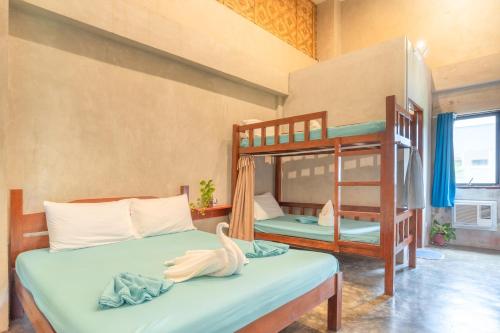 a bedroom with two bunk beds with a swan on the bed at Sinag Hostel in General Luna