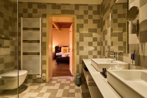 ビルゼンにあるB&B Huize Briersのバスルーム(洗面台2台、トイレ付)、ベッドルーム1室が備わります。