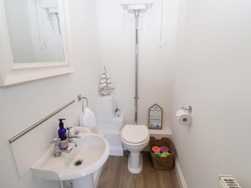 a white bathroom with a toilet and a sink at Old Felixstowe, Bath Road in Felixstowe