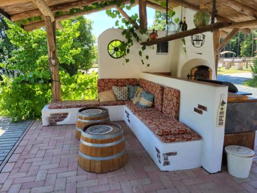 a patio with a couch and two barrels at Hacienda del Piero in Poppendorf im Burgenland