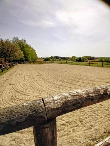 a wooden fence on a field with a dirt field at Hacienda del Piero in Poppendorf im Burgenland